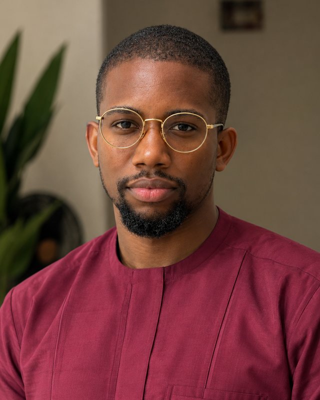 Anuri Onyeukwu in his burgundy kaftan and gold-rimmed glasses
